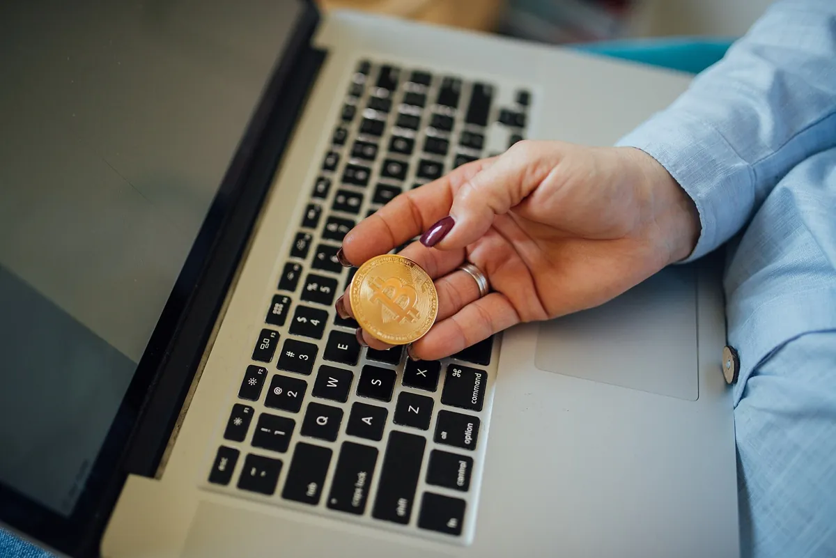 Pièce physique de bitcoin tenue dans la main