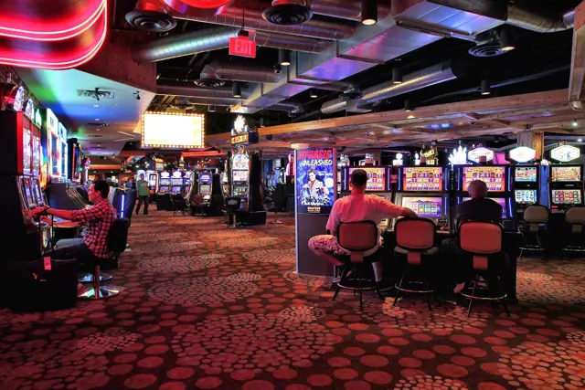 Rangées de machines à sous dans une salle de jeux